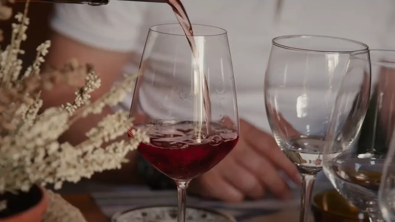 Rotwein wird in ein Glas eingeschenkt